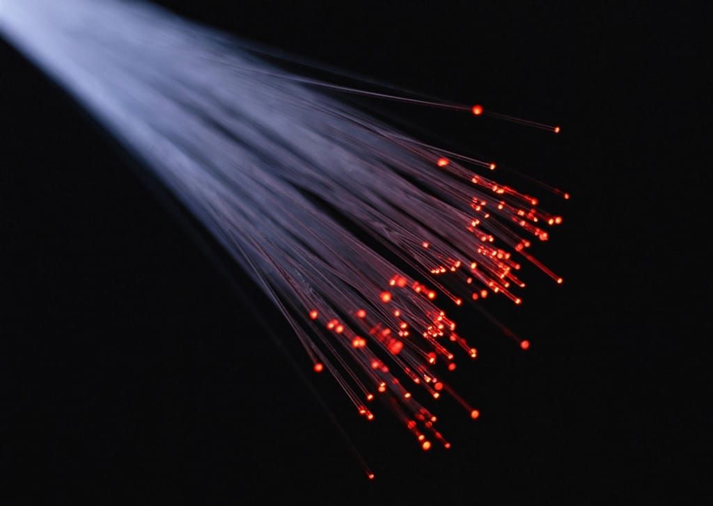 Feixe de fibras ópticas com a luz vermelha aparecendo nas pontas